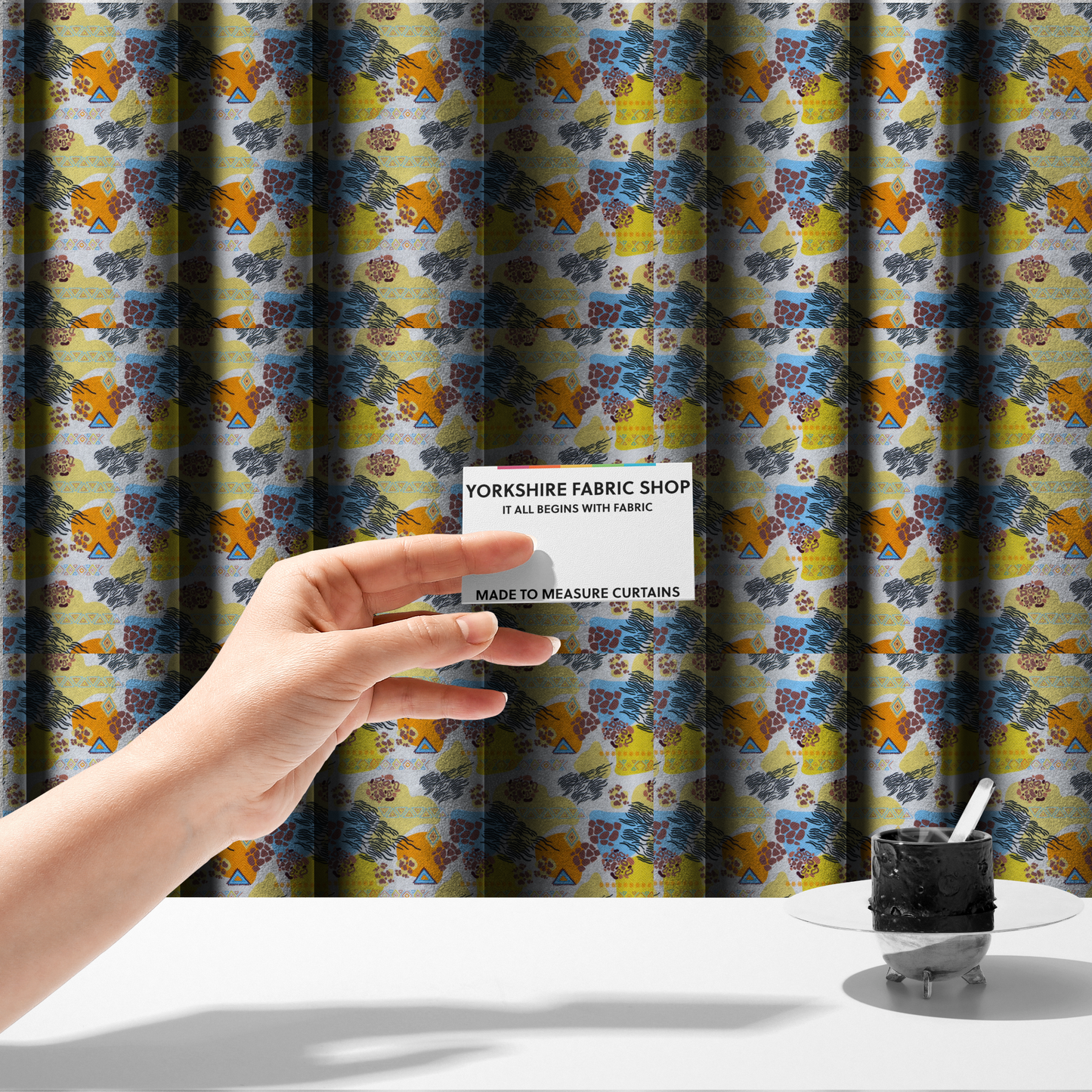 The fabric used to create these made-to-measure curtains is a vibrant, safari-themed repeating pattern on a white textured fabric, blending abstract shapes with traditional animal and tribal motifs.