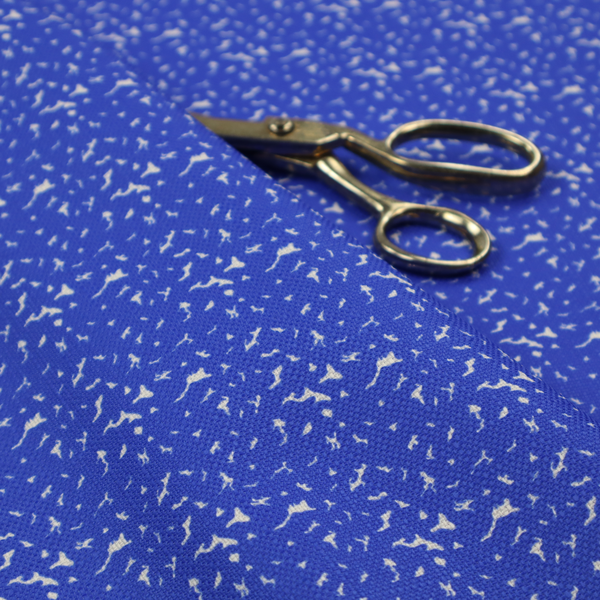 A bright cobalt blue fabric with a dense, non-directional "speckle" or "splatter" pattern.