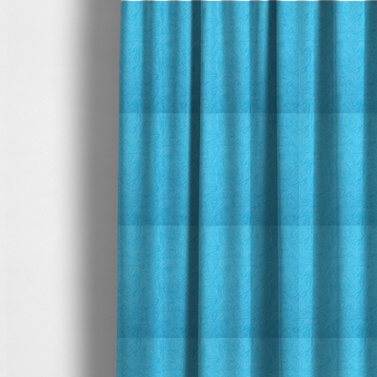 The fabric used to create these made-to-measure curtains is a vibrant cyan-coloured fabric featuring a subtle, tonal geometric pattern.