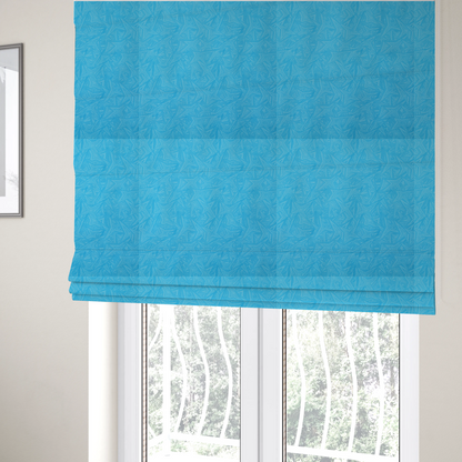 The fabric used to create these Roman blinds is a vibrant cyan-coloured fabric featuring a subtle, tonal geometric pattern.