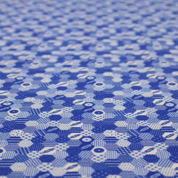 A detailed geometric fabric featuring a dense honeycomb or hexagonal patchwork pattern in blue and white.