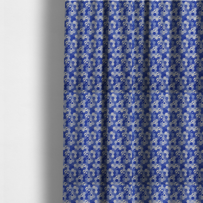 The fabric used to create these made-to-measure curtains is a detailed geometric fabric featuring a dense honeycomb or hexagonal patchwork pattern in blue and white.