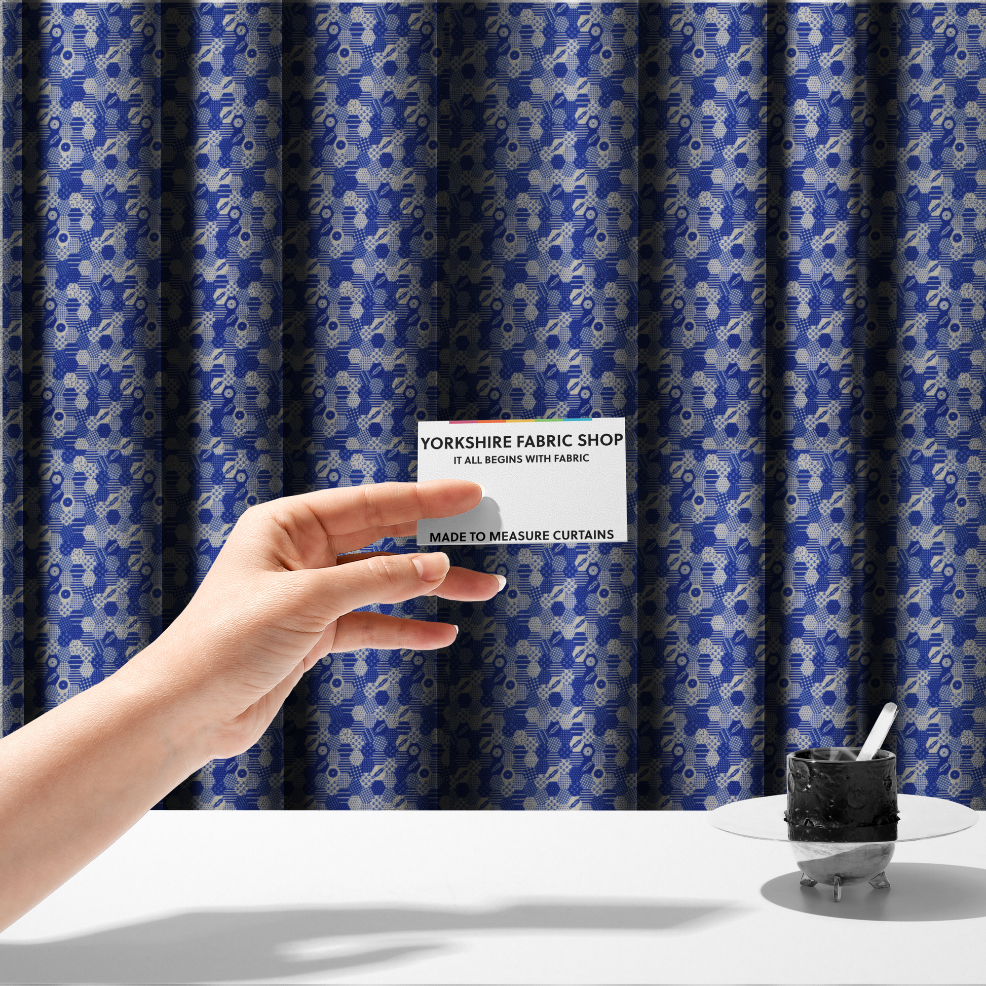 The fabric used to create these made-to-measure curtains is a detailed geometric fabric featuring a dense honeycomb or hexagonal patchwork pattern in blue and white.