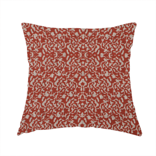 The fabric used to create this handmade cushions is a decorative textile featuring a symmetrical, kaleidoscopic pattern in red and beige. The intricate, interlocking organic shapes create a dense, filigree-like design with a slightly weathered or distressed look. The fabric has a visible, fine-textured weave that gives the pattern a soft, matte appearance.