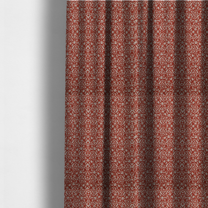 The fabric used to create these made-to-measure curtains is a decorative textile featuring a symmetrical, kaleidoscopic pattern in red and beige. The intricate, interlocking organic shapes create a dense, filigree-like design with a slightly weathered or distressed look. The fabric has a visible, fine-textured weave that gives the pattern a soft, matte appearance.