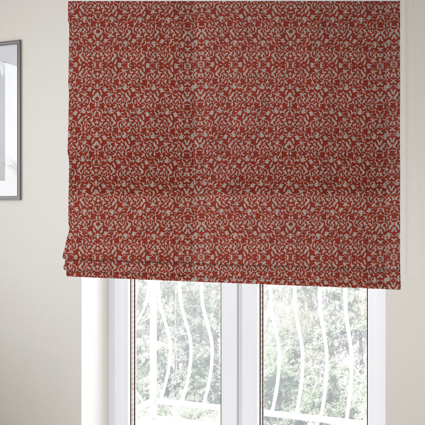 The fabric used to create these Roman blinds is a decorative textile featuring a symmetrical, kaleidoscopic pattern in red and beige. The intricate, interlocking organic shapes create a dense, filigree-like design with a slightly weathered or distressed look. The fabric has a visible, fine-textured weave that gives the pattern a soft, matte appearance.