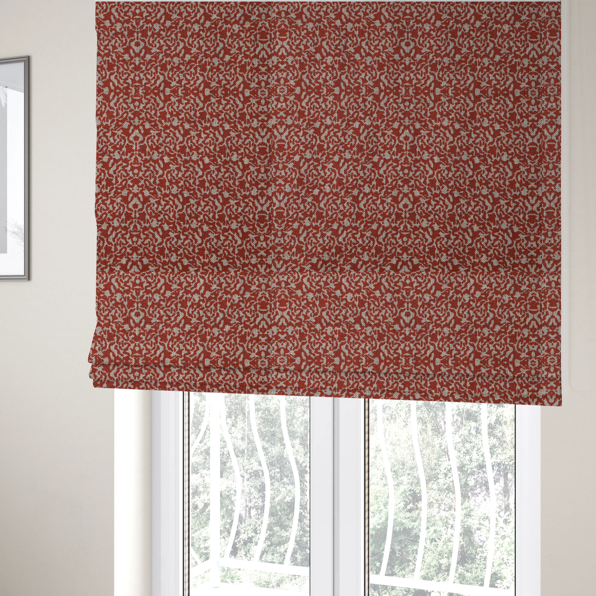 The fabric used to create these Roman blinds is a decorative textile featuring a symmetrical, kaleidoscopic pattern in red and beige. The intricate, interlocking organic shapes create a dense, filigree-like design with a slightly weathered or distressed look. The fabric has a visible, fine-textured weave that gives the pattern a soft, matte appearance.