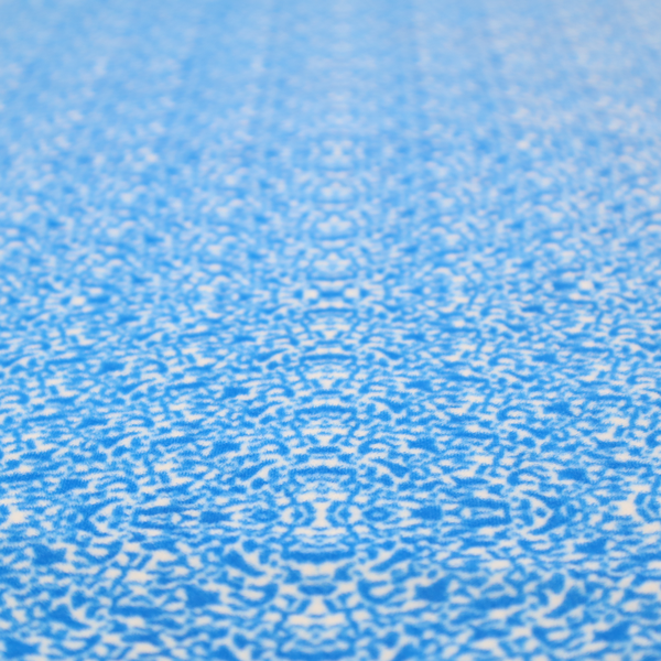 This fabric is a symmetrical, kaleidoscopic textile pattern in bright azure blue and white. The design features intricate, interlocking organic shapes mirrored vertically and horizontally to create a dense, mosaic-like filigree across the fabric.