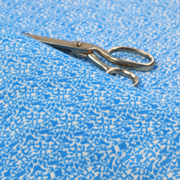 This fabric is a symmetrical, kaleidoscopic textile pattern in bright azure blue and white. The design features intricate, interlocking organic shapes mirrored vertically and horizontally to create a dense, mosaic-like filigree across the fabric.