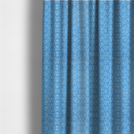 The fabric used to create these made-to-measure curtains is a symmetrical, kaleidoscopic textile pattern in bright azure blue and white. The design features intricate, interlocking organic shapes mirrored vertically and horizontally to create a dense, mosaic-like filigree across the fabric.