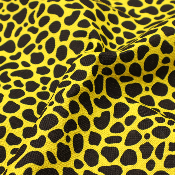 A bold cheetah-style animal print featuring irregular, black organic spots scattered across a bright canary yellow background.
