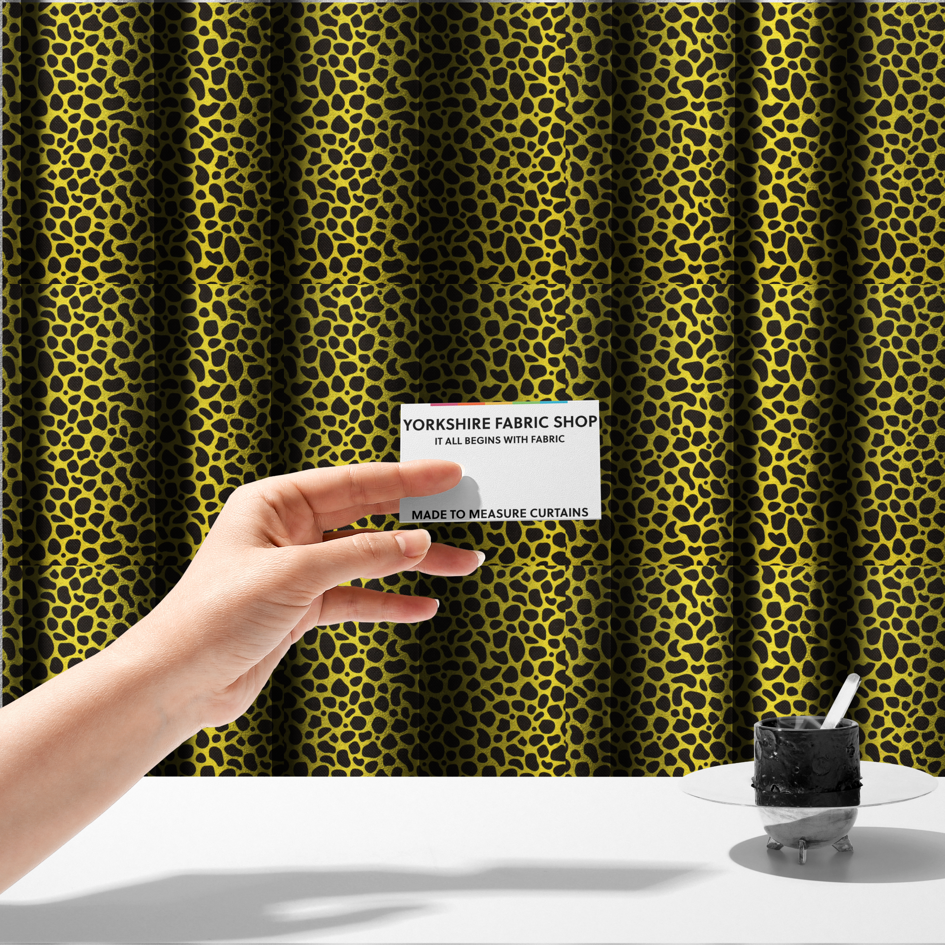 The fabric used to create these made-to-measure curtains is a bold cheetah-style animal print featuring irregular, black organic spots scattered across a bright canary yellow background.