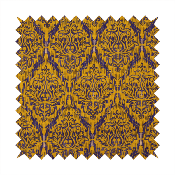 This fabric features a royal blue damask pattern layered over a deep mustard gold background. The design has an ikat-inspired finish, with vertical, feathered edges that give the ornate fleur-de-lis motifs a slightly blurred, textured appearance.