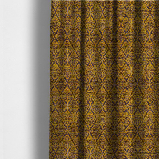 The fabric used to create these made-to-measure curtains features a royal blue damask pattern layered over a deep mustard gold background. The design has an ikat-inspired finish, with vertical, feathered edges that give the ornate fleur-de-lis motifs a slightly blurred, textured appearance.