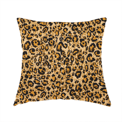 The fabric used to create this handmade cushions consists of irregular, organic black "rosette" shapes with golden-tan centres, set against a warm, sandy-beige background, creating a style of leopard print. The fabric has a visible textured, canvas-like weave, giving the pattern a slightly rugged and tactile appearance.