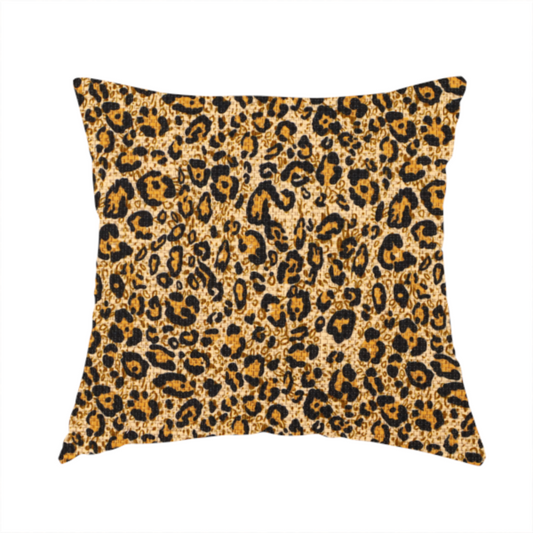 The fabric used to create this handmade cushions consists of irregular, organic black "rosette" shapes with golden-tan centres, set against a warm, sandy-beige background, creating a style of leopard print. The fabric has a visible textured, canvas-like weave, giving the pattern a slightly rugged and tactile appearance.