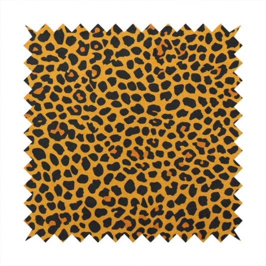 A high-contrast animal print fabric featuring a dense leopard-inspired pattern. The design consists of irregular black spots and open rosettes with warm orange-brown centres, set against a vibrant mustard-yellow background. The print is small-scale and tightly packed, with a visible fine-grained textile texture
