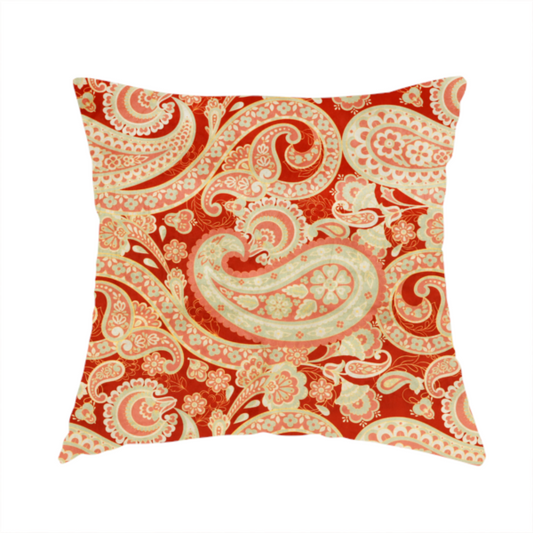 The fabric used to create this handmade cushion is a vibrant, warm-toned textile featuring large-scale paisley teardrop motifs in shades of cream, pale mint, and soft orange against a bold red background. The intricate patterns within the paisley shapes include delicate floral borders and internal mandalas, surrounded by smaller scattered flower accents for a rich, traditional Indian-inspired aesthetic.