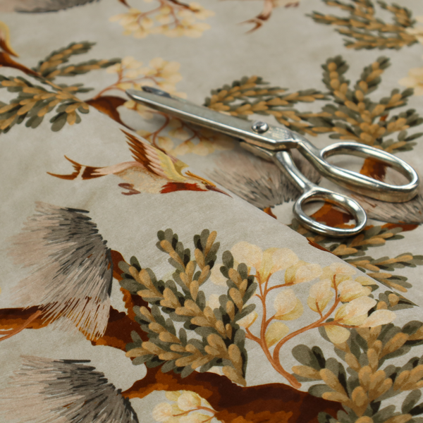 A sophisticated textile featuring a Chinoiserie-style pattern with stylized birds in flight among winding, dark brown tree branches. The branches are adorned with clusters of pale cream blossoms and soft, pine-like needles. The entire design is set against a muted beige background creating a serene and classical aesthetic.