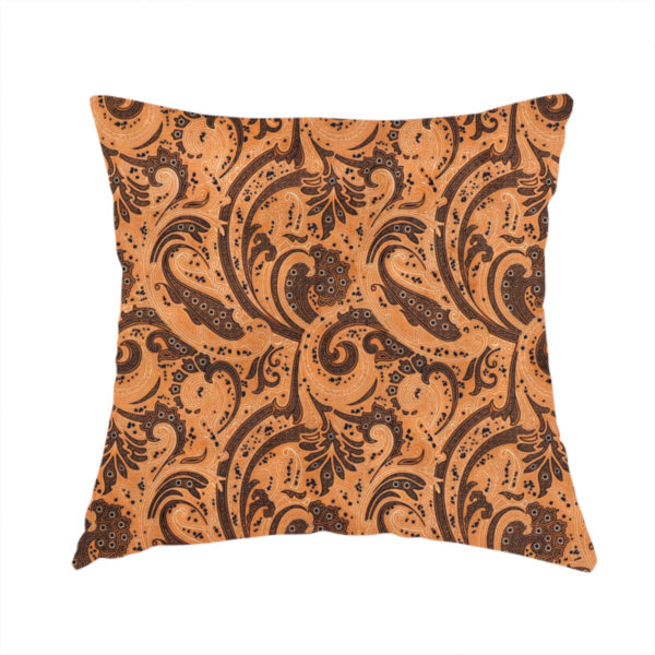 The fabric used to create this handmade cushion is a complex textile design featuring an all-over paisley and scroll pattern in solid black over a warm copper-orange background. The motifs are highly stylized with a mixture of dotted textures, fine line work, and bold curves that resemble ocean waves or flowing vines. The high-contrast colour palette gives the fabric a sophisticated, bohemian-luxe appearance.