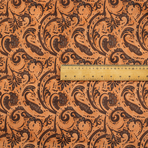 A complex textile design featuring an all-over paisley and scroll pattern in solid black over a warm copper-orange background. The motifs are highly stylized with a mixture of dotted textures, fine line work, and bold curves that resemble ocean waves or flowing vines. The high-contrast colour palette gives the fabric a sophisticated, bohemian-luxe appearance.