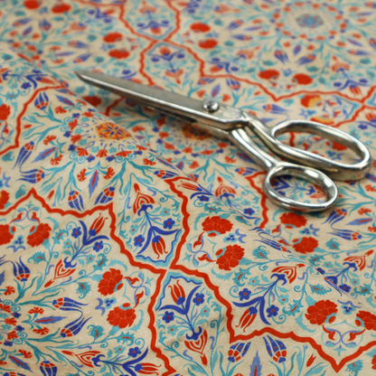 A decorative fabric with an Ottoman-style floral print. The design consists of repeating cobalt blue and turquoise tulips and deep red carnations intertwined with long, curving green leaves. The pattern mimics 16th-century Mediterranean ceramic tile art.