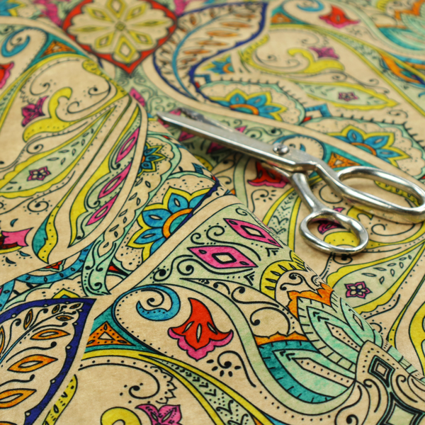 Vibrant bohemian paisley fabric with an intricate damask-style pattern featuring teal, yellow, pink, and orange motifs accented by bold black outlines on a warm cream background.