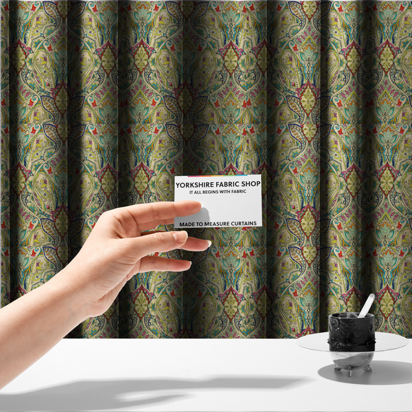 The fabric used to create these made-to-measure curtains is a vibrant bohemian paisley fabric with an intricate damask-style pattern featuring teal, yellow, pink, and orange motifs accented by bold black outlines on a warm cream background