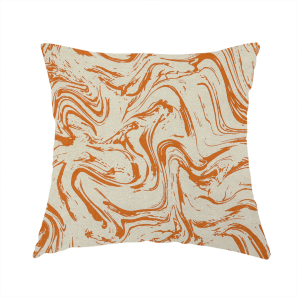 The fabric used to create this handmade cushion is an abstract marbled fabric featuring fluid, organic swirls in a warm burnt orange colour over a textured cream-colored background.