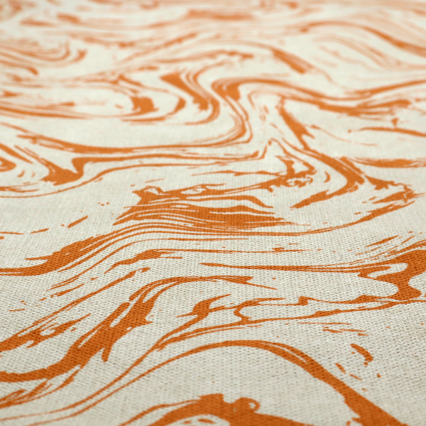Abstract marbled fabric featuring fluid, organic swirls in a warm burnt orange colour over a textured cream-colored background.