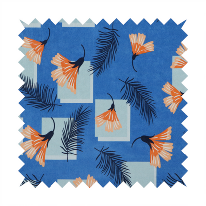Modern tropical fabric featuring a vibrant cobalt blue background with scattered orange fan-shaped flowers, dark navy palm fronds, and pale blue geometric square overlays.