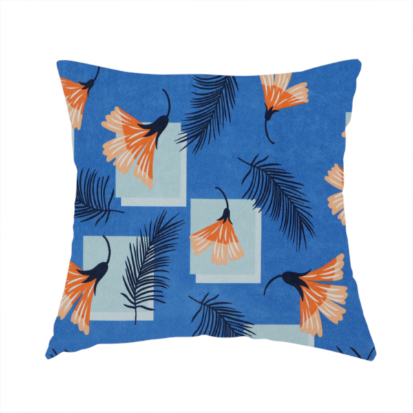The fabric used to create this handmade cushions is a modern tropical fabric featuring a vibrant cobalt blue background with scattered orange fan-shaped flowers, dark navy palm fronds, and pale blue geometric square overlays.