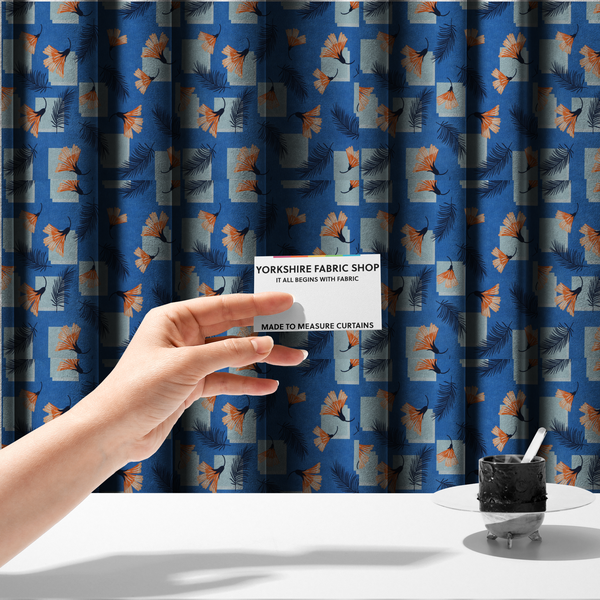 The fabric used to create these made-to-measure curtains is a modern tropical fabric featuring a vibrant cobalt blue background with scattered orange fan-shaped flowers, dark navy palm fronds, and pale blue geometric square overlays.