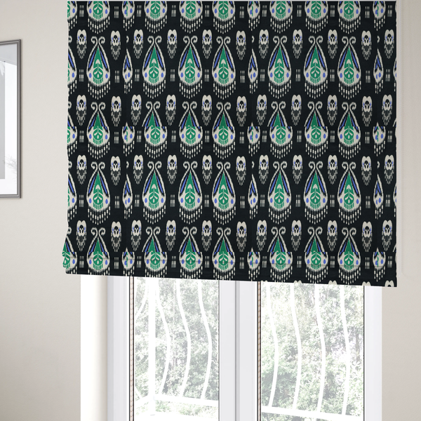 The fabric used to create these Roman blinds is a dark textile featuring rows of floating, feathered ikat medallions. The design glows with emerald green and bright sapphire blue against a deep obsidian background, accented by crisp white geometric tassels and swirling crown-like scrollwork.