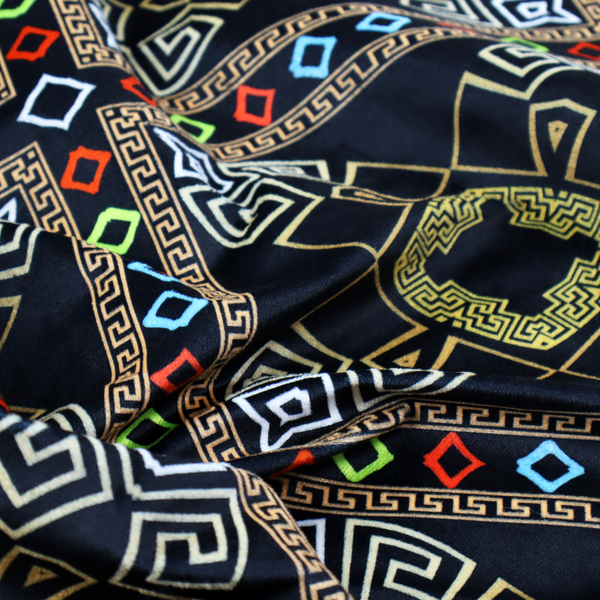 Luxury black fabric featuring a structured gold Greek Key and geometric medallion pattern, bordered by a vibrant row of small neon red, green, and blue diamond shapes.
