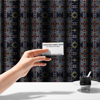 The fabric used to create these made-to-measure curtains is a luxury black fabric featuring a structured gold Greek Key and geometric medallion pattern, bordered by a vibrant row of small neon red, green, and blue diamond shapes.