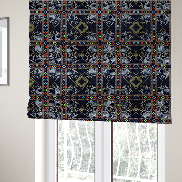 The fabric used to create these Roman blinds is a luxury black fabric featuring a structured gold Greek Key and geometric medallion pattern, bordered by a vibrant row of small neon red, green, and blue diamond shapes.