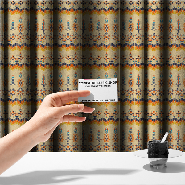 The fabric used to create these made-to-measure curtains is a folk-art style fabric featuring horizontal rows of stylized orange and navy floral pillars and geometric chevron borders on a warm cream background