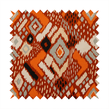 Bohemian ikat fabric featuring a dense diamond pattern in burnt orange, cream, and charcoal black with distressed, hand-stamped textures.