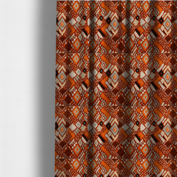 The fabric used to create these made-to-measure curtains is a bohemian ikat fabric featuring a dense diamond pattern in burnt orange, cream, and charcoal black with distressed, hand-stamped textures.