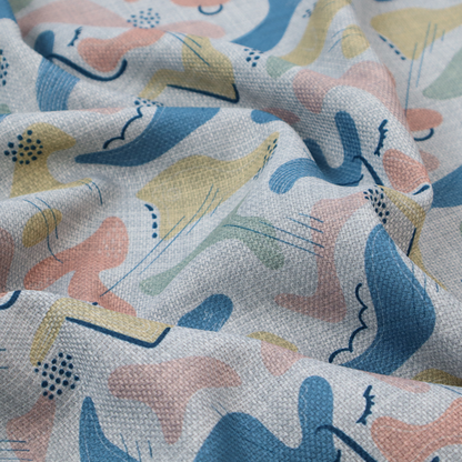 Abstract mid-century modern fabric featuring fluid organic shapes in dusty blue, blush pink, and mustard yellow with fine black line accents and stippled dot clusters on a light grey linen-textured background.