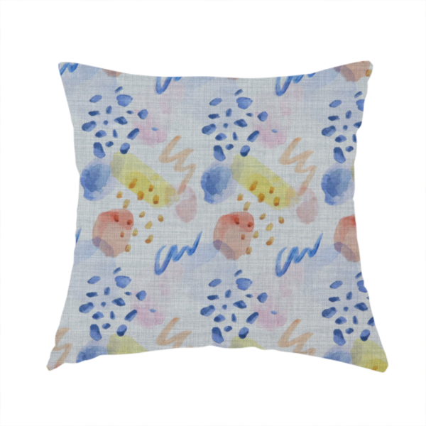 The fabric used to create these handmade cushions is an abstract watercolour pattern of blue, ochre, and peach shapes with squiggly lines and navy dots on a light grey linen-textured background.