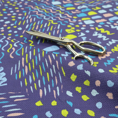 A dense abstract pattern featuring a variety of hand-drawn squiggles, dots, and dashes in bright, contrasting tones scattered across a deep, dark-coloured textured fabric.