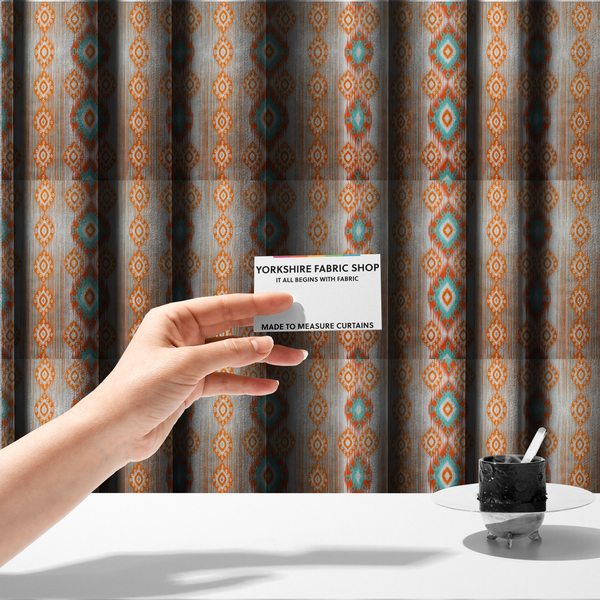 The fabric used to create these made-to-measure curtains is a striking geometric fabric featuring vibrant diamond medallions with blurred, ikat-style edges layered over a dynamic pattern of fine vertical streaks on a light background.