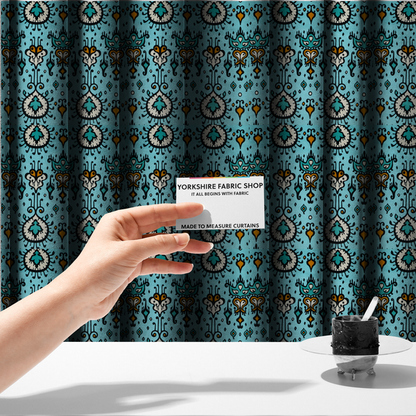 The fabric used to create these made-to-measure curtains is a symmetrical folk-art pattern featuring large ornamental medallions and vertical tribal motifs with feathered, ikat-inspired edges on a solid, light-toned background.