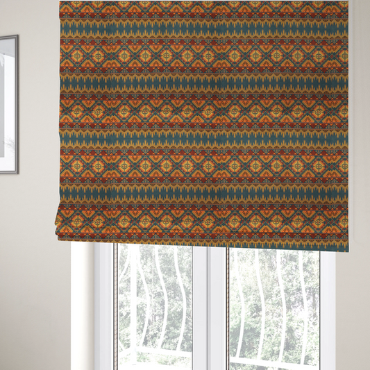 The fabric used to create these Roman blinds is a detailed geometric fabric featuring tiered horizontal bands of intricate diamond motifs, zig-zag patterns, and sharp tribal-style linework in warm, sun-drenched tones.