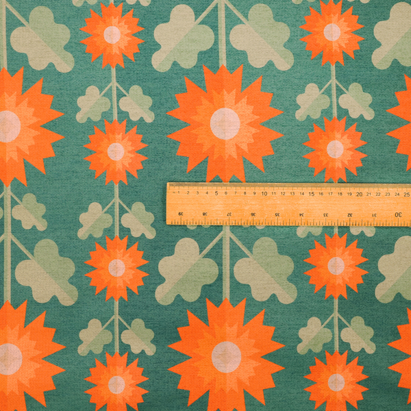 This fabric features a retro-inspired geometric floral pattern with a distinct mid-century modern aesthetic. The design is structured in vertical columns against a textured, deep teal-green background.