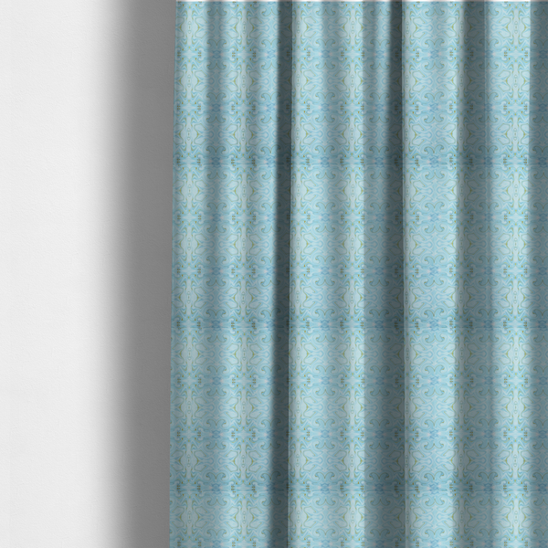 The fabric used to create these made-to-measure curtains is a repeating, symmetrical pattern of fluid, marble-like swirls in shades of sky blue, white, and subtle golden-yellow on a light blue background.
