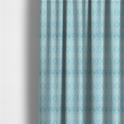 The fabric used to create these made-to-measure curtains is a repeating, symmetrical pattern of fluid, marble-like swirls in shades of sky blue, white, and subtle golden-yellow on a light blue background.