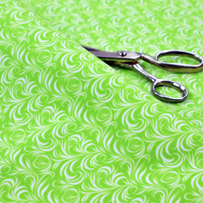 A vibrant, lime-green fabric featuring a dense, repeating pattern of elegant, white, swirling botanical motifs